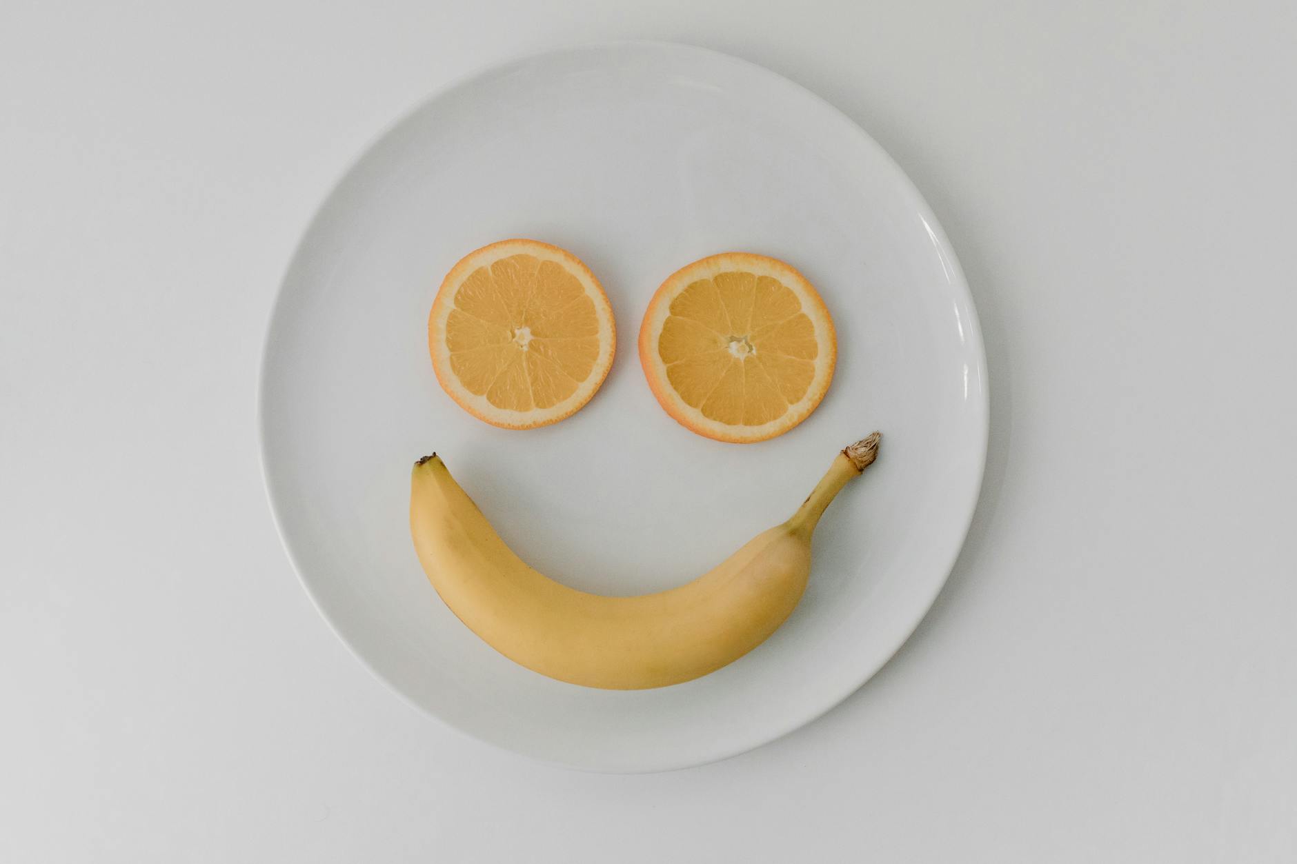 orange slices and banana on white ceramic plate