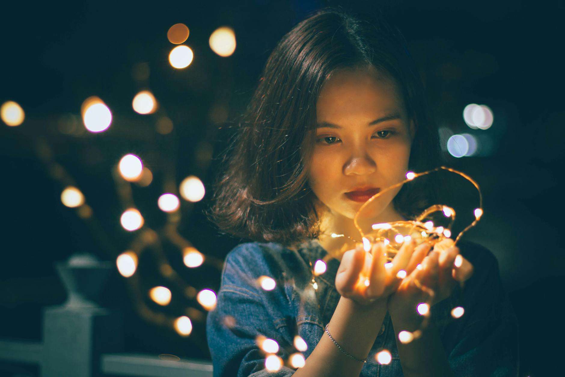 close up photography of woman holding sting lights