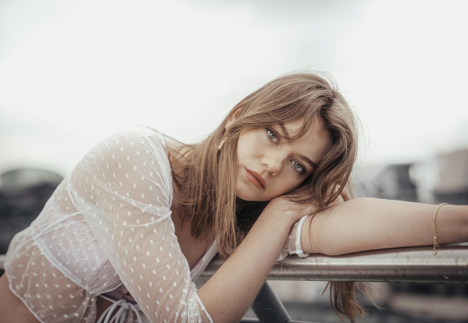 photo of a sad young woman leaning her head on her arms