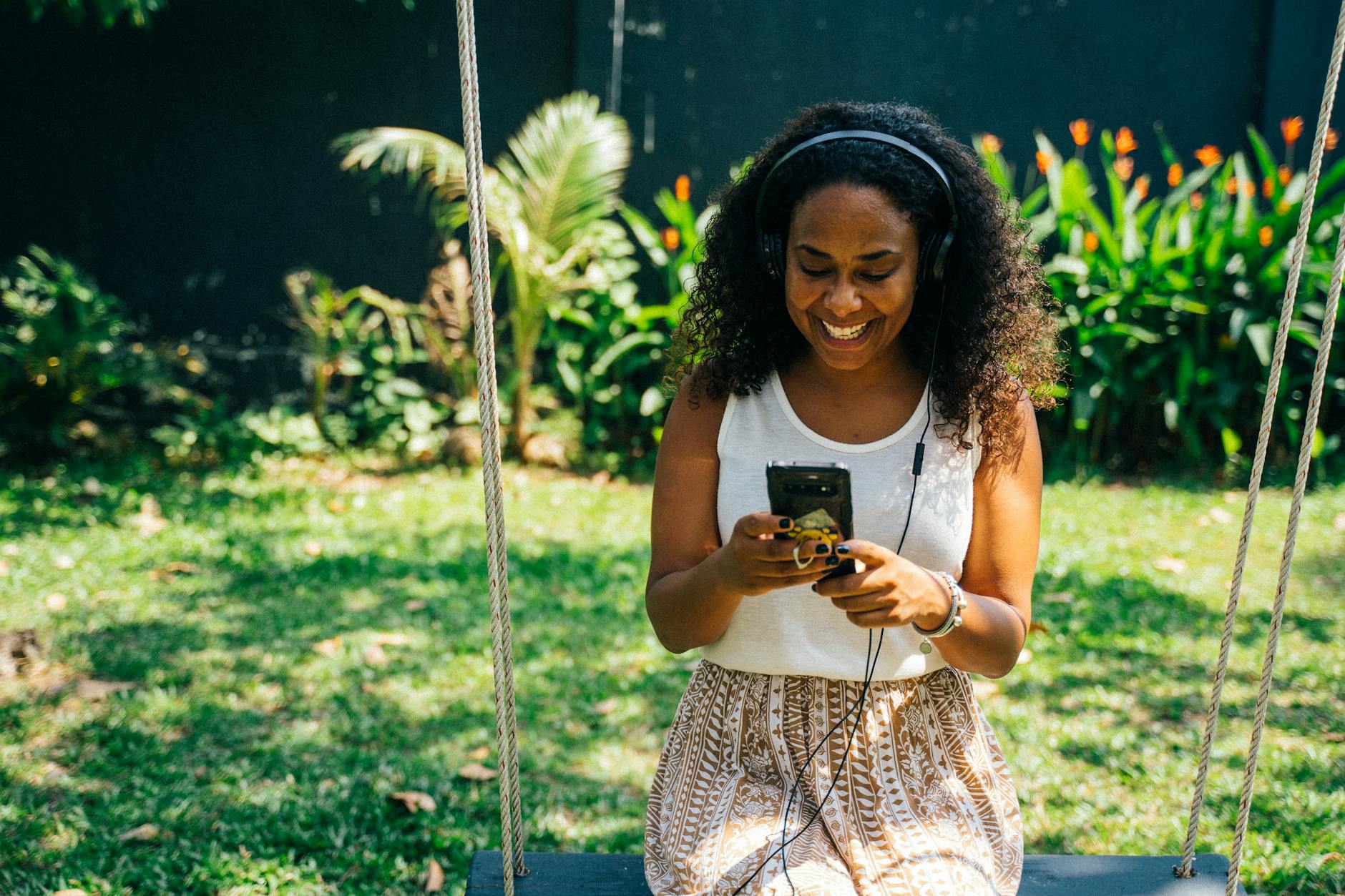 pexels-photo-7229090 - KINDCOMPASSCOACH woman in white top holding her phone listening to self-help podcasts