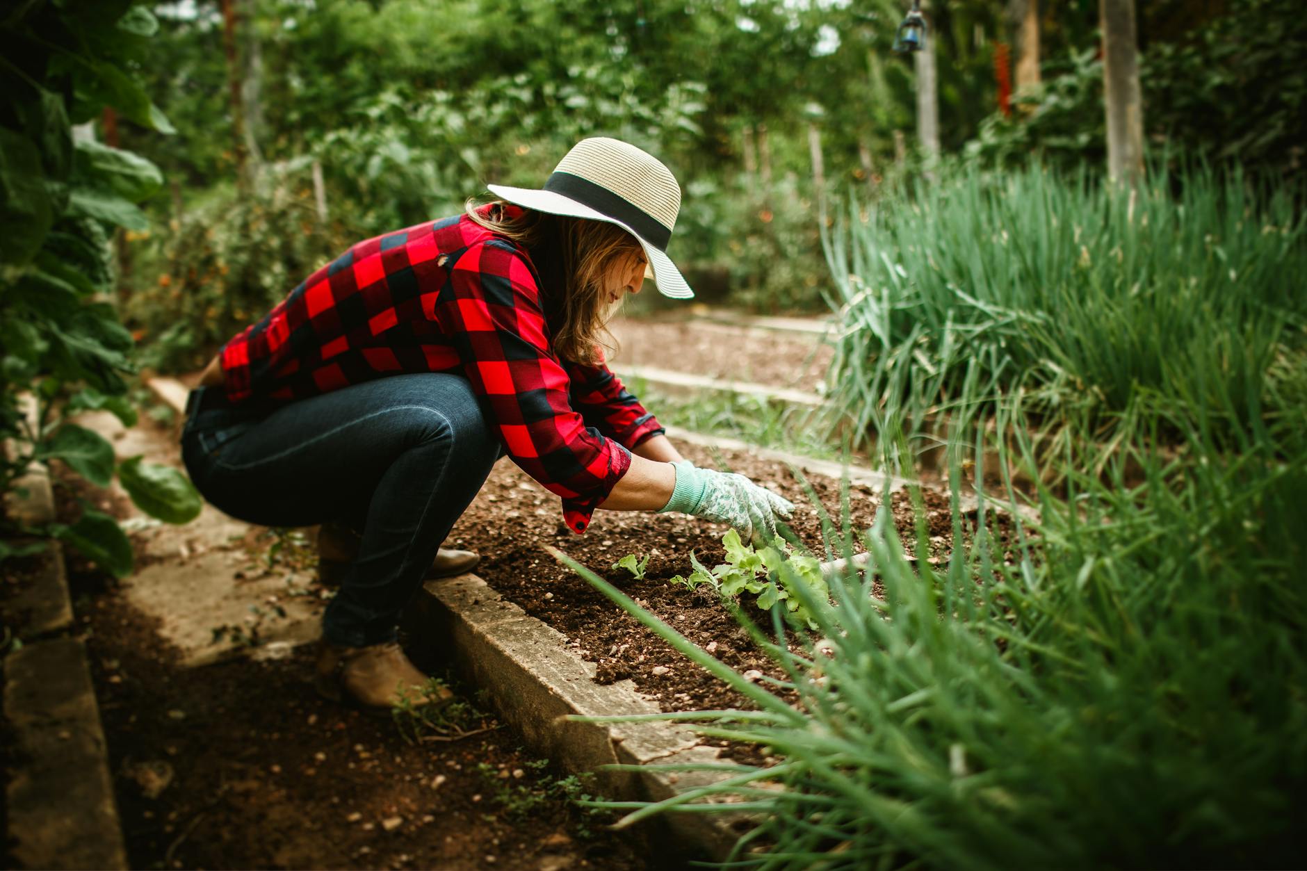 woman in hat working in garden