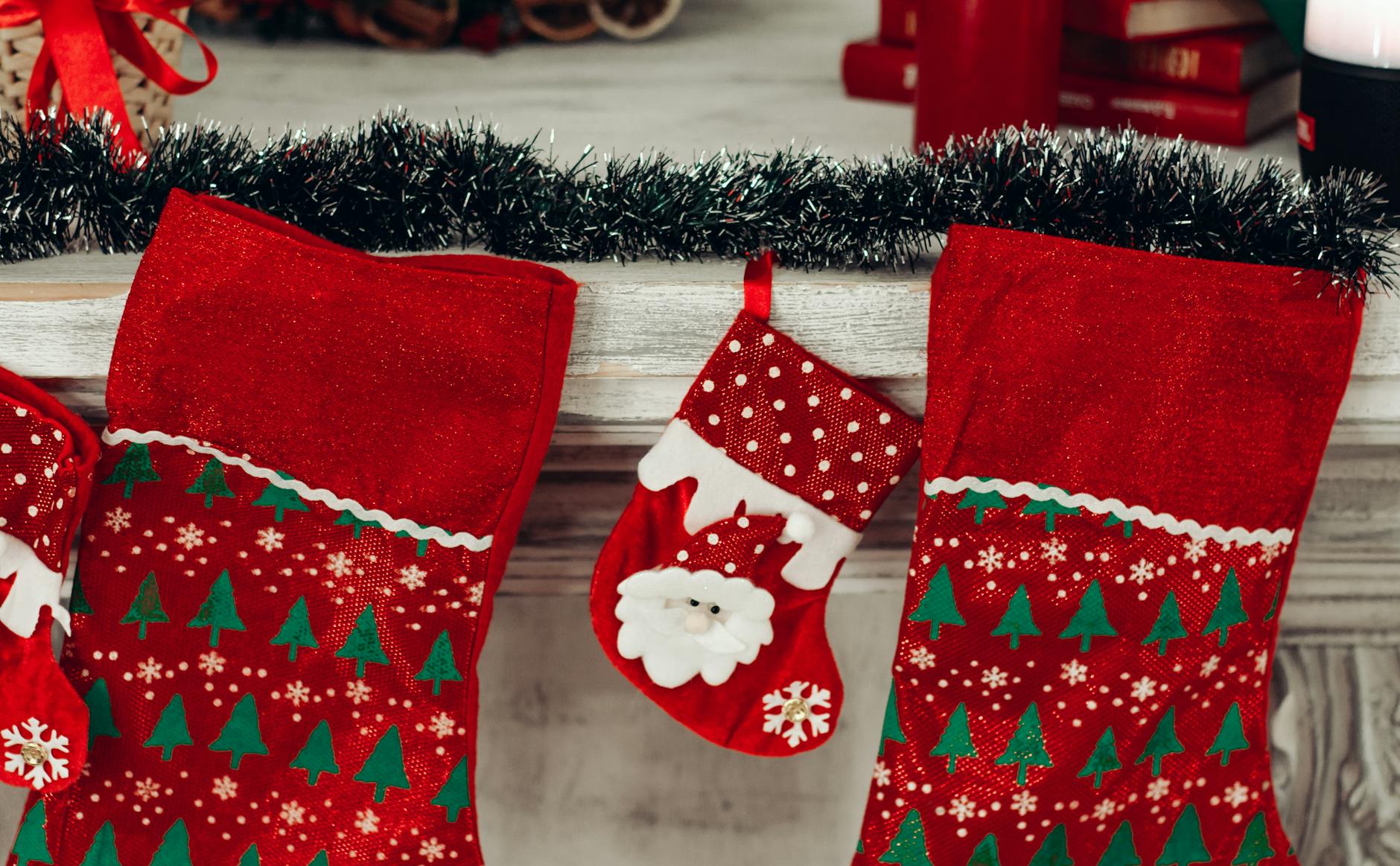 three red and green christmas stocking mounted on wall