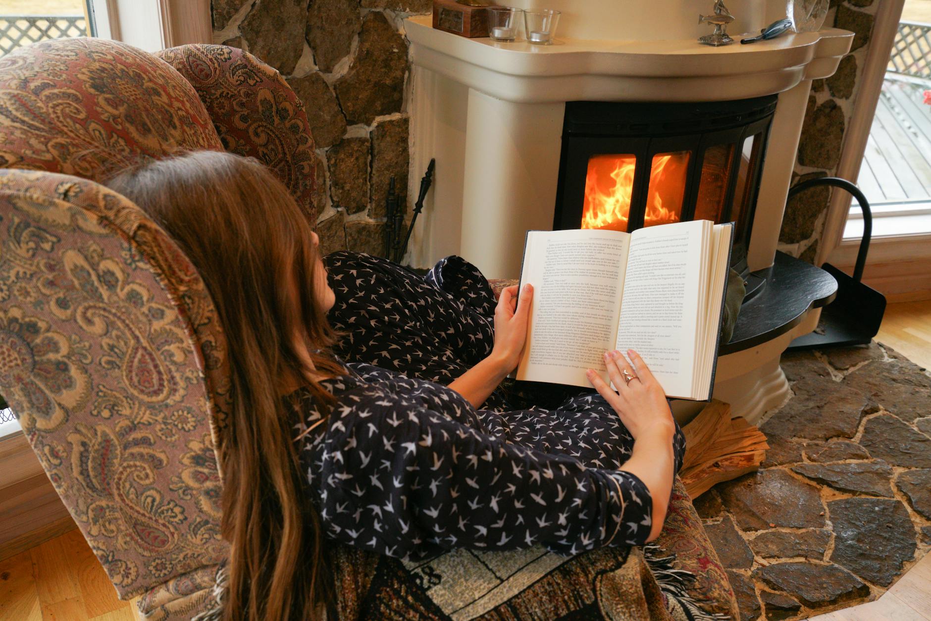 woman reading book on armchair