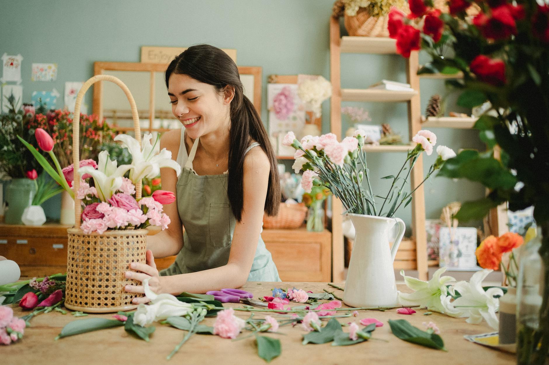 cheerful woman decorating bouquet in basket