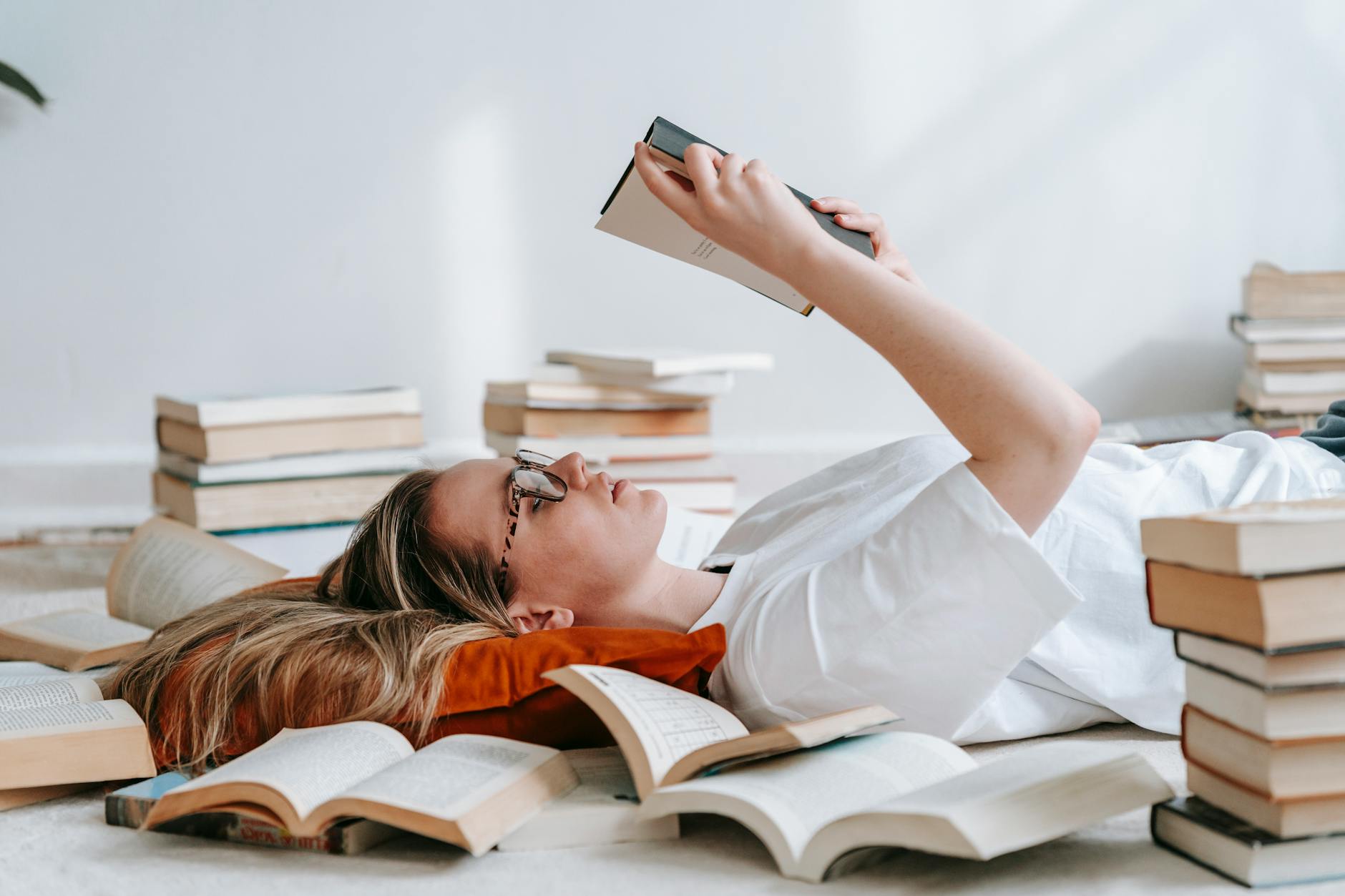 young smart woman reading book on floor