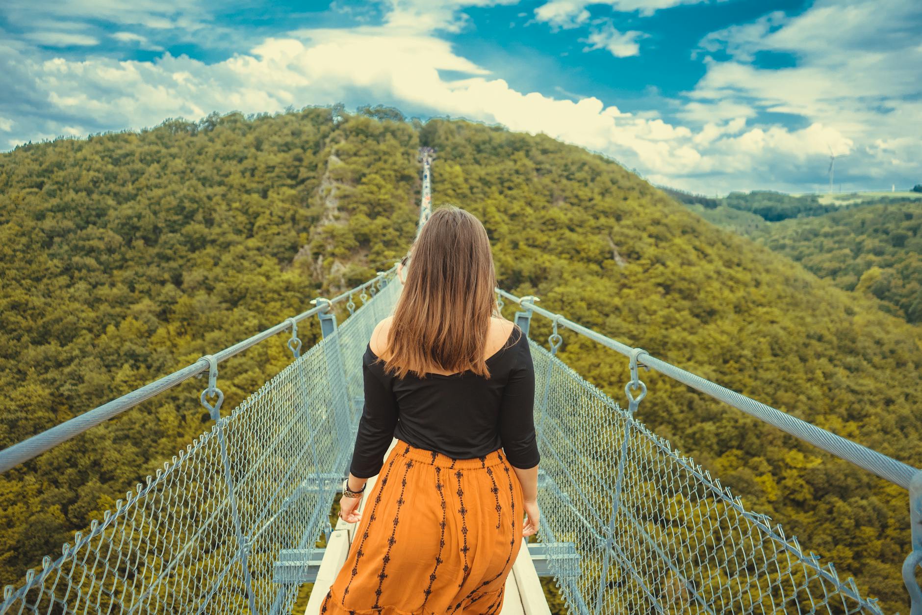 photo of woman walking on a canopy walkway