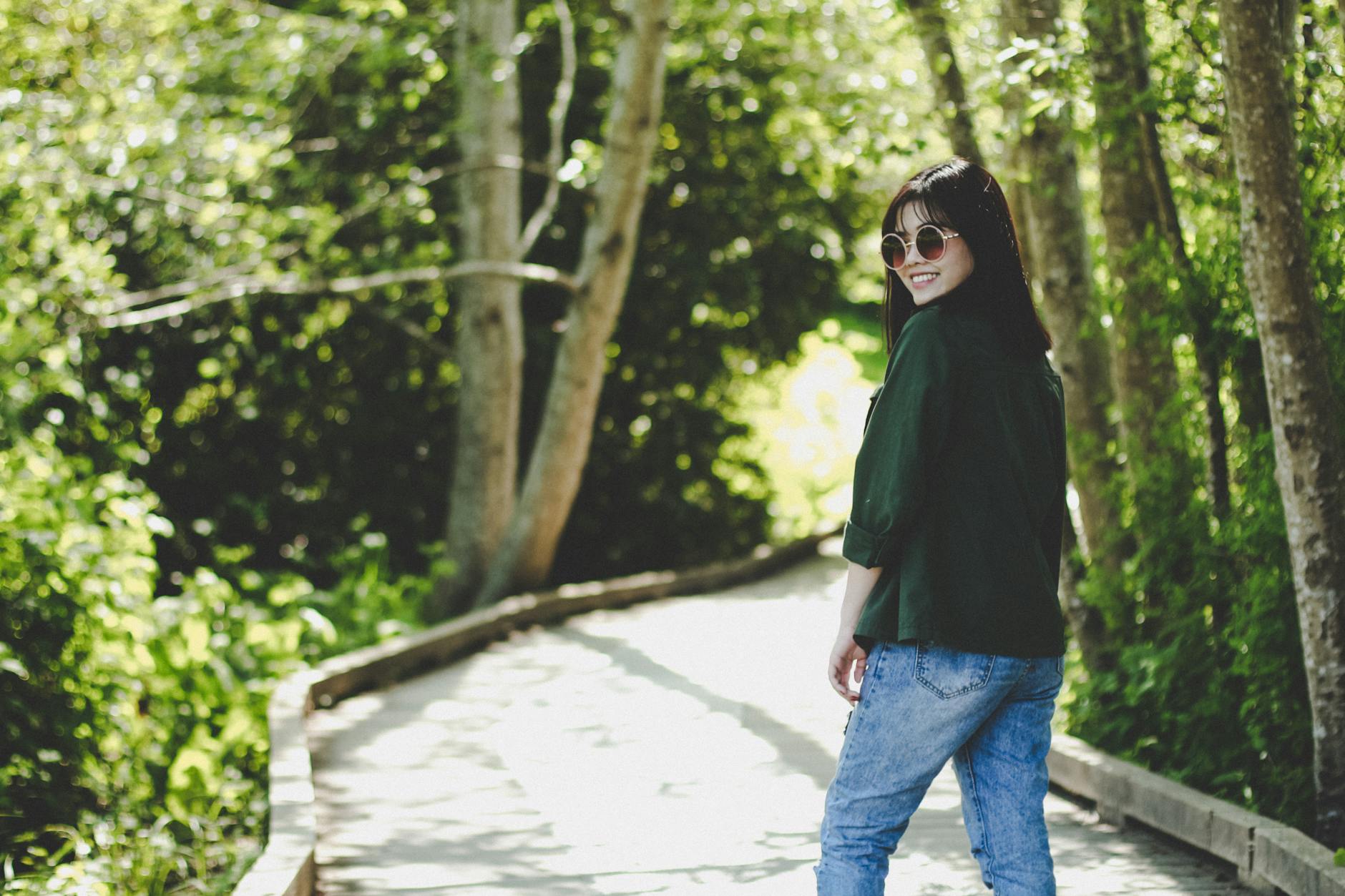 smiling woman standing near tree