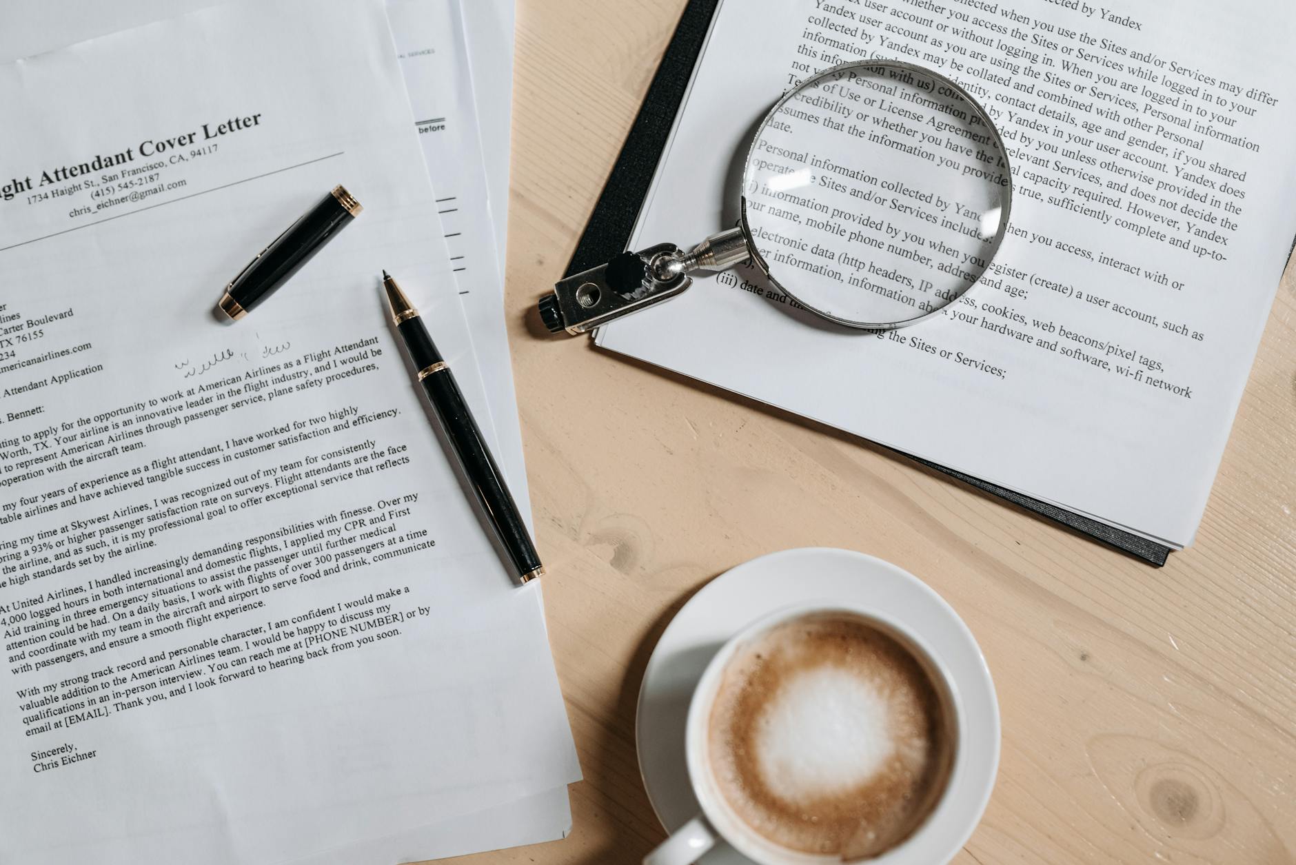 coffee pen and magnifying glass on papers