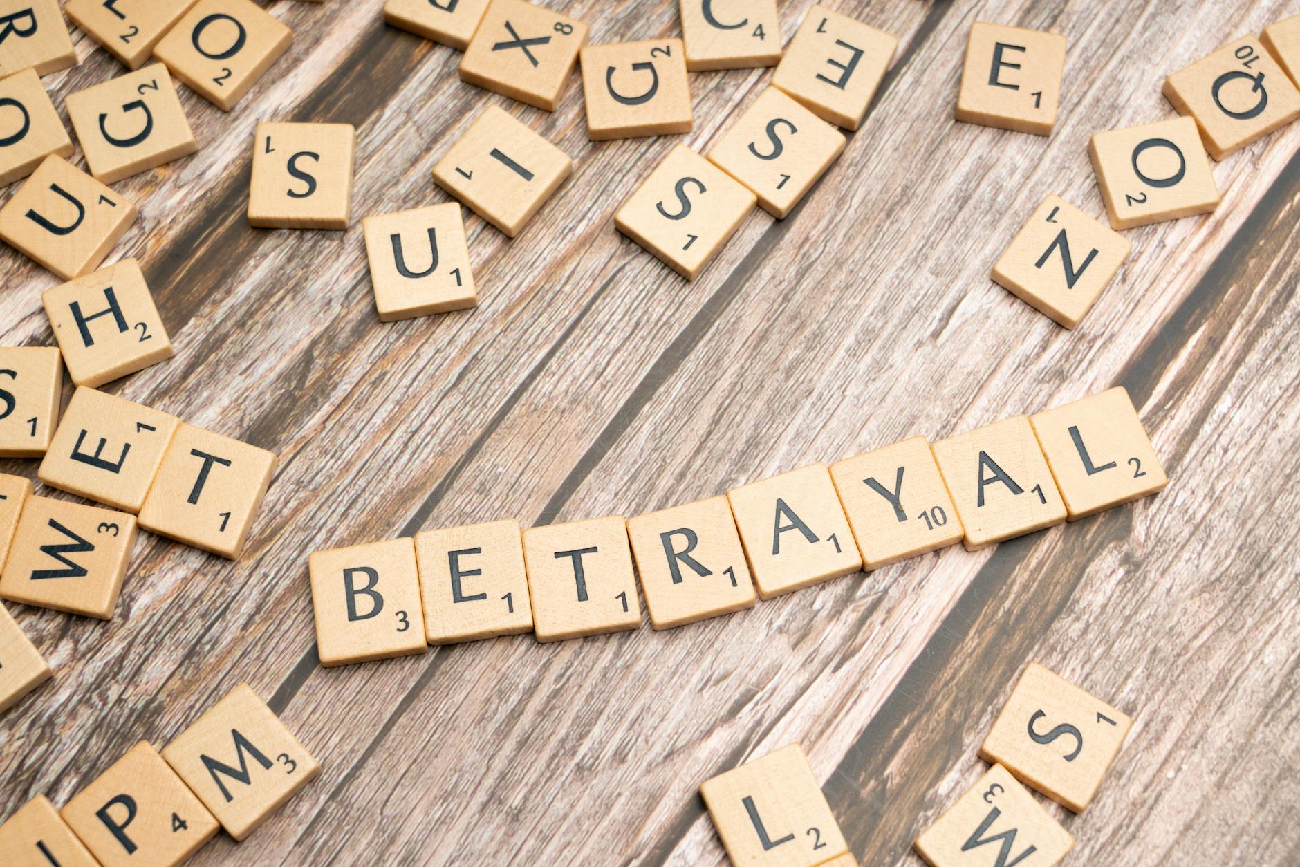 the word betrayal spelled out in scrabble tiles