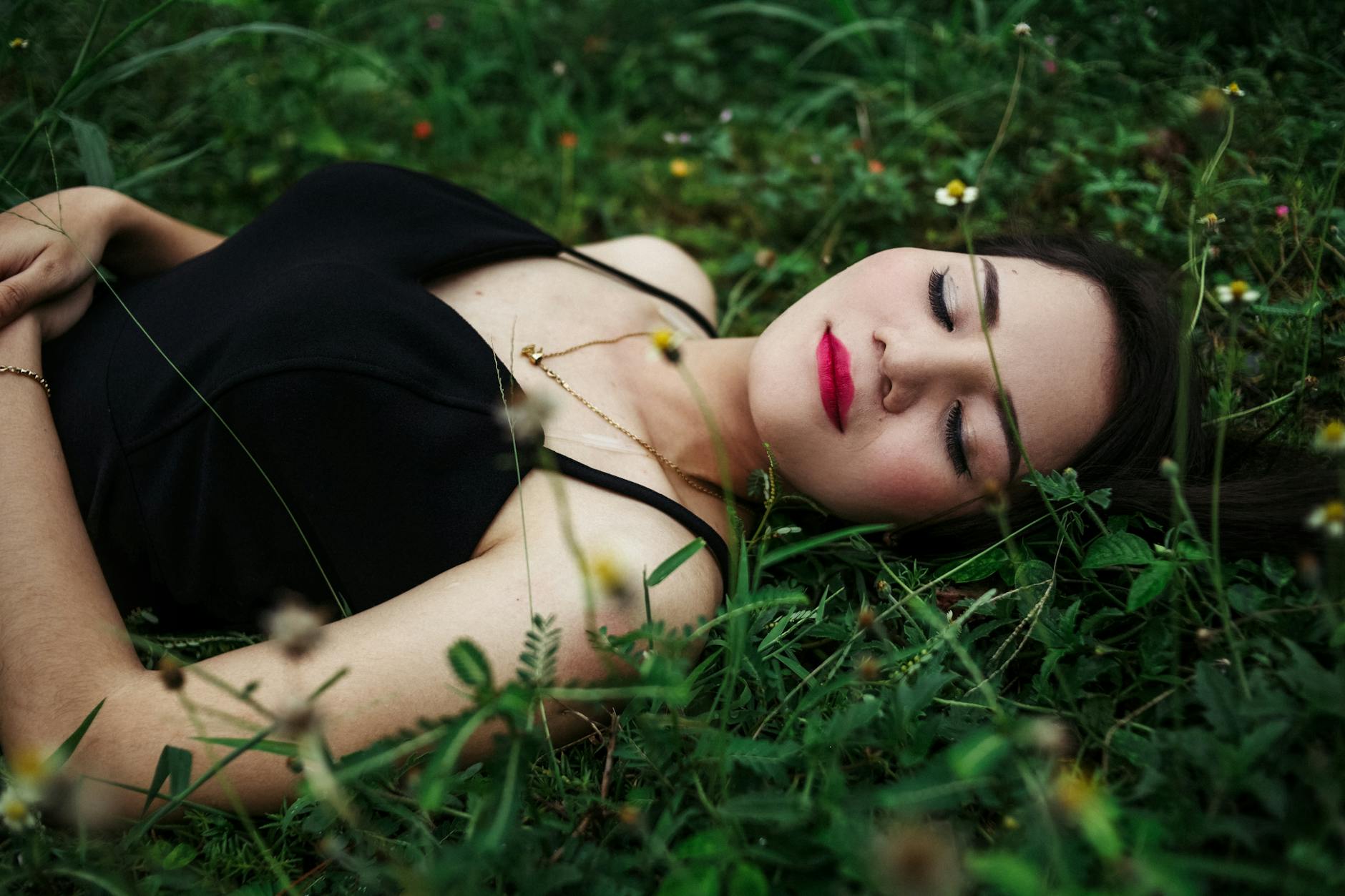 stylish woman with bright makeup resting on lawn