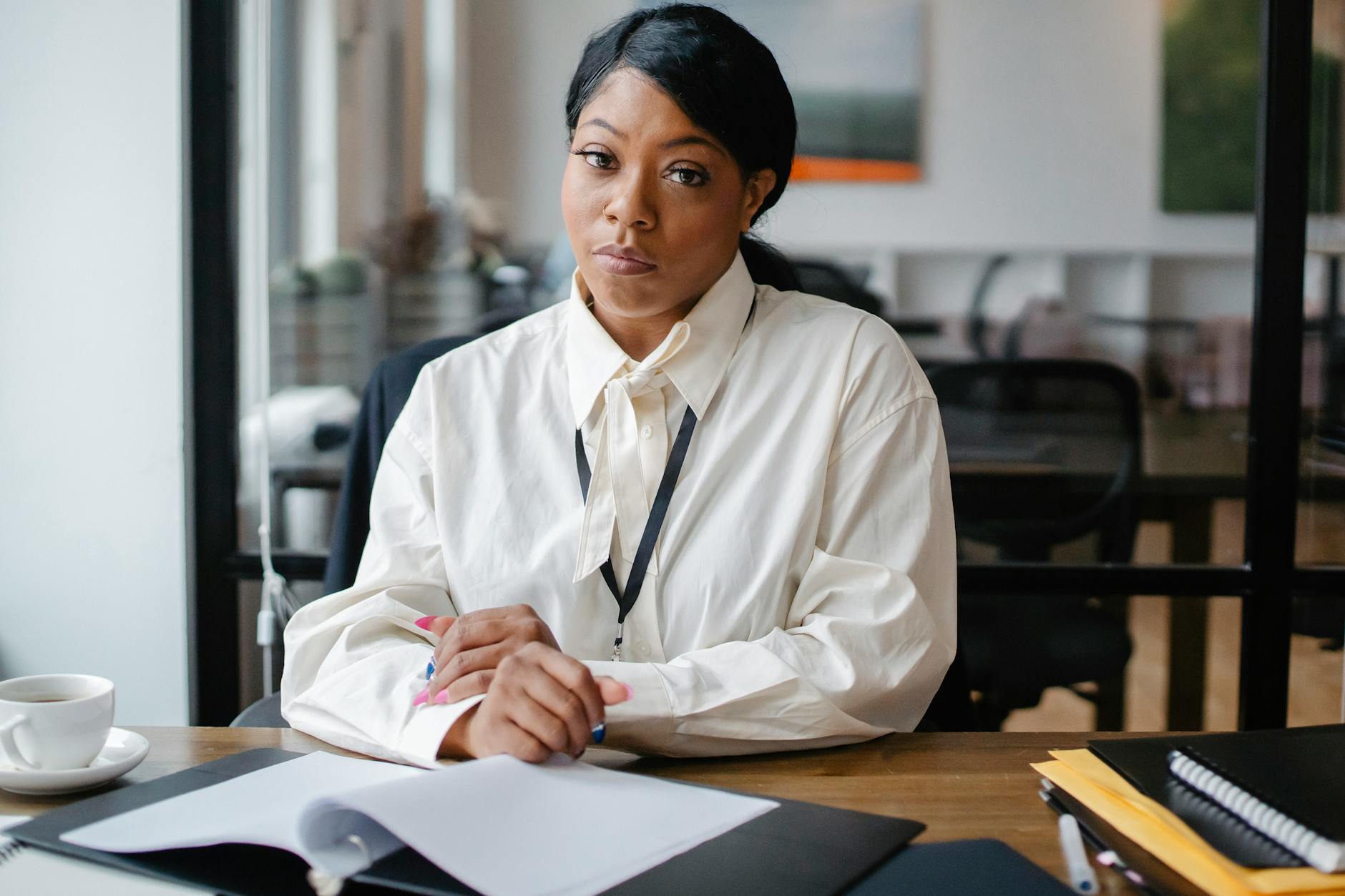 serious black businesswoman sitting at desk in office