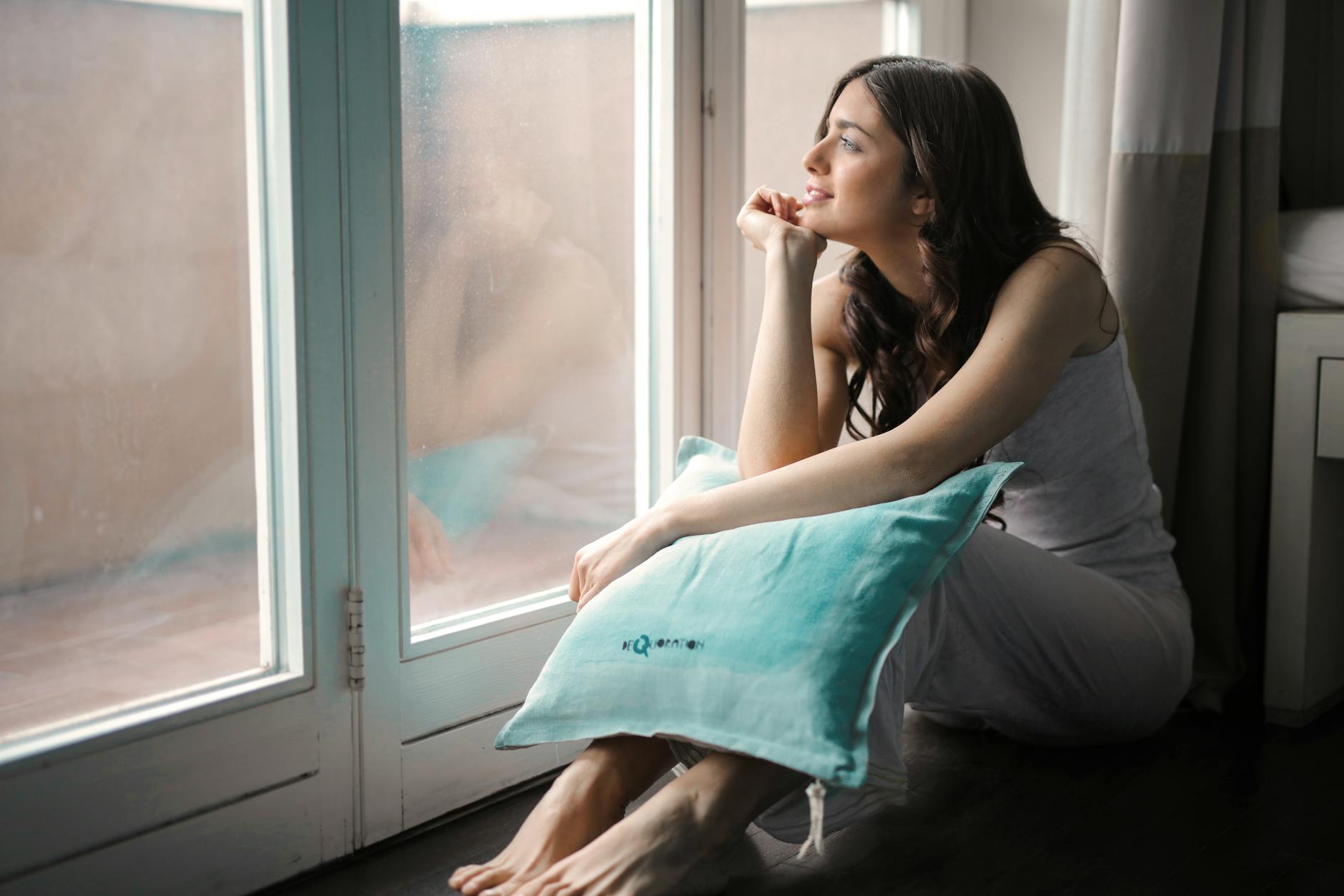 woman holding teal pillow