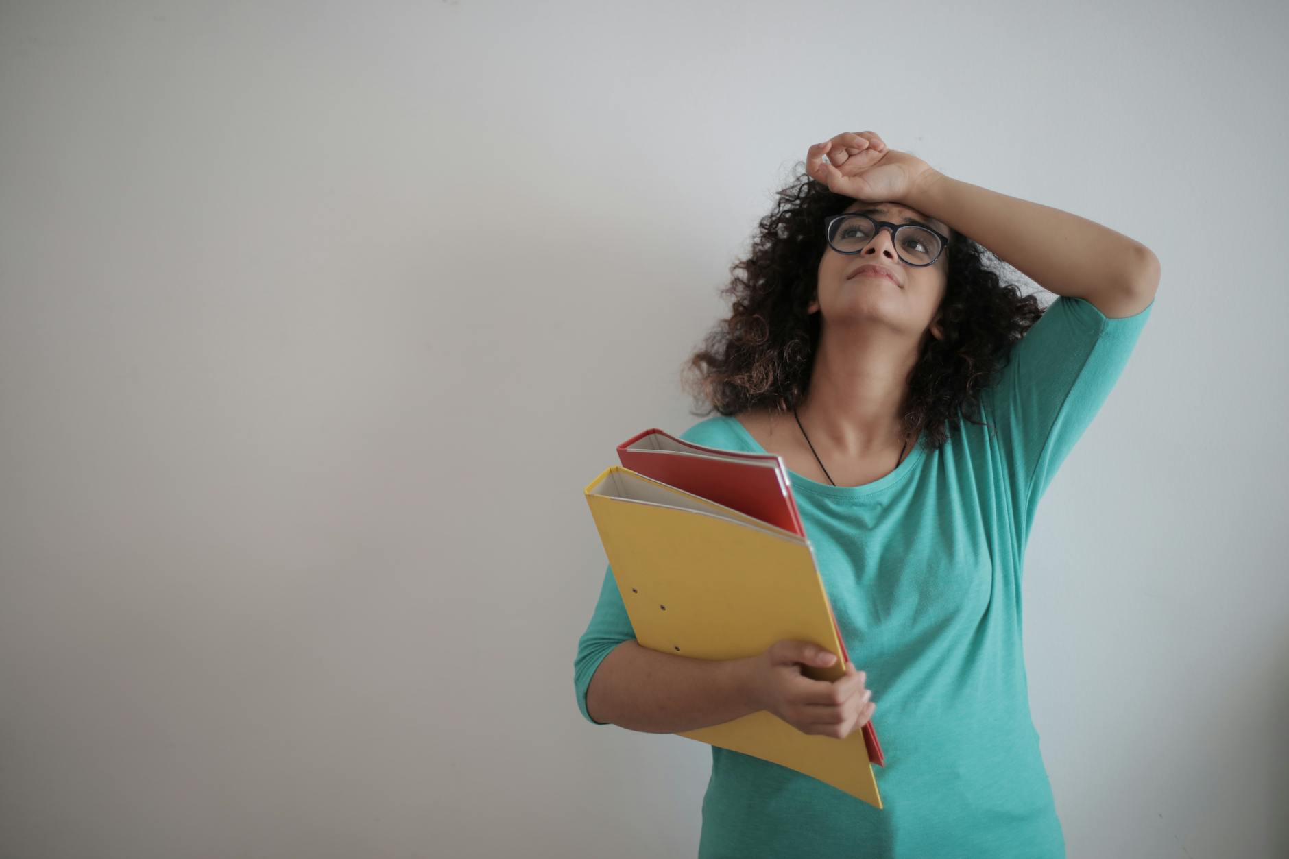 overworked adult female entrepreneur with papers in light modern office