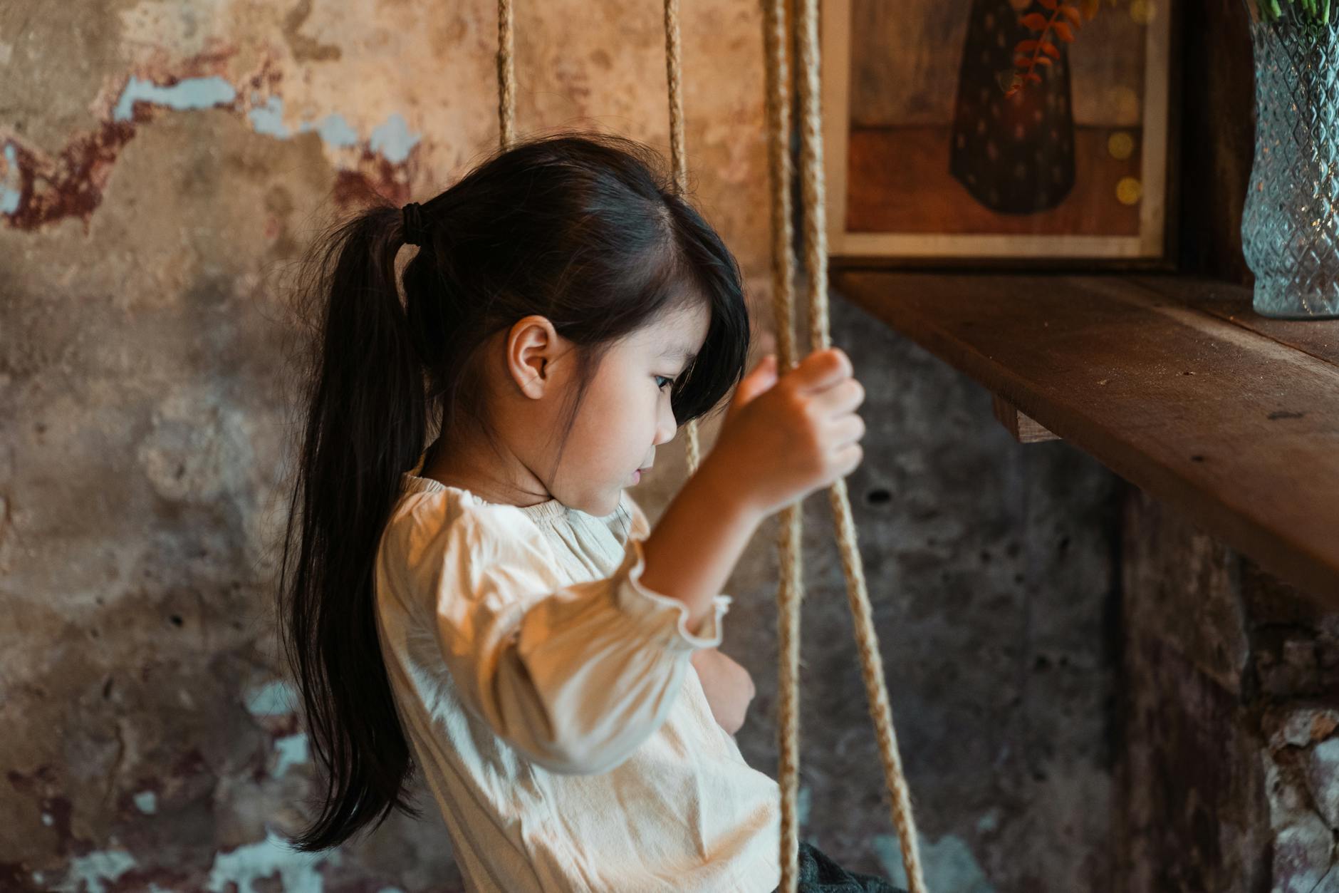 calm little girl riding on swing