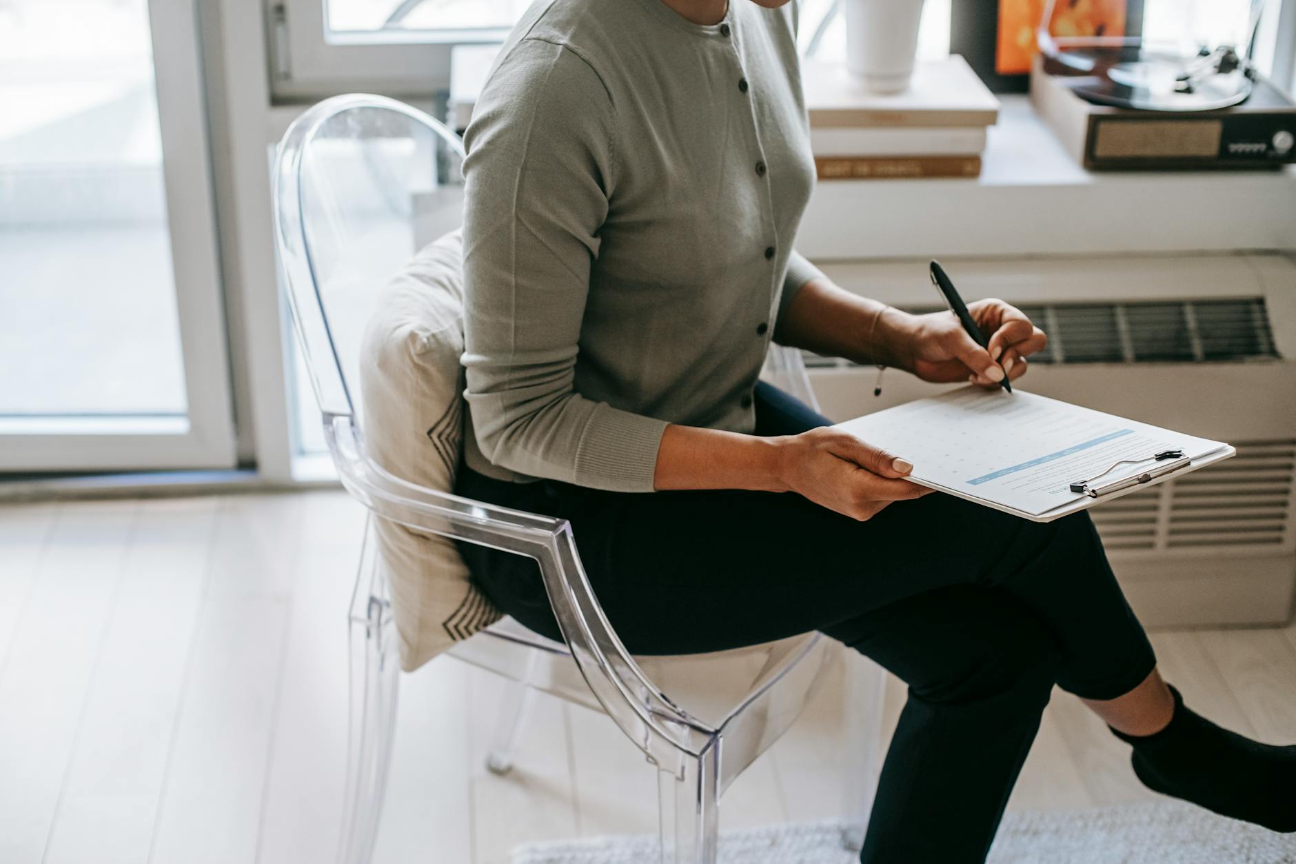 crop woman writing on clipboard