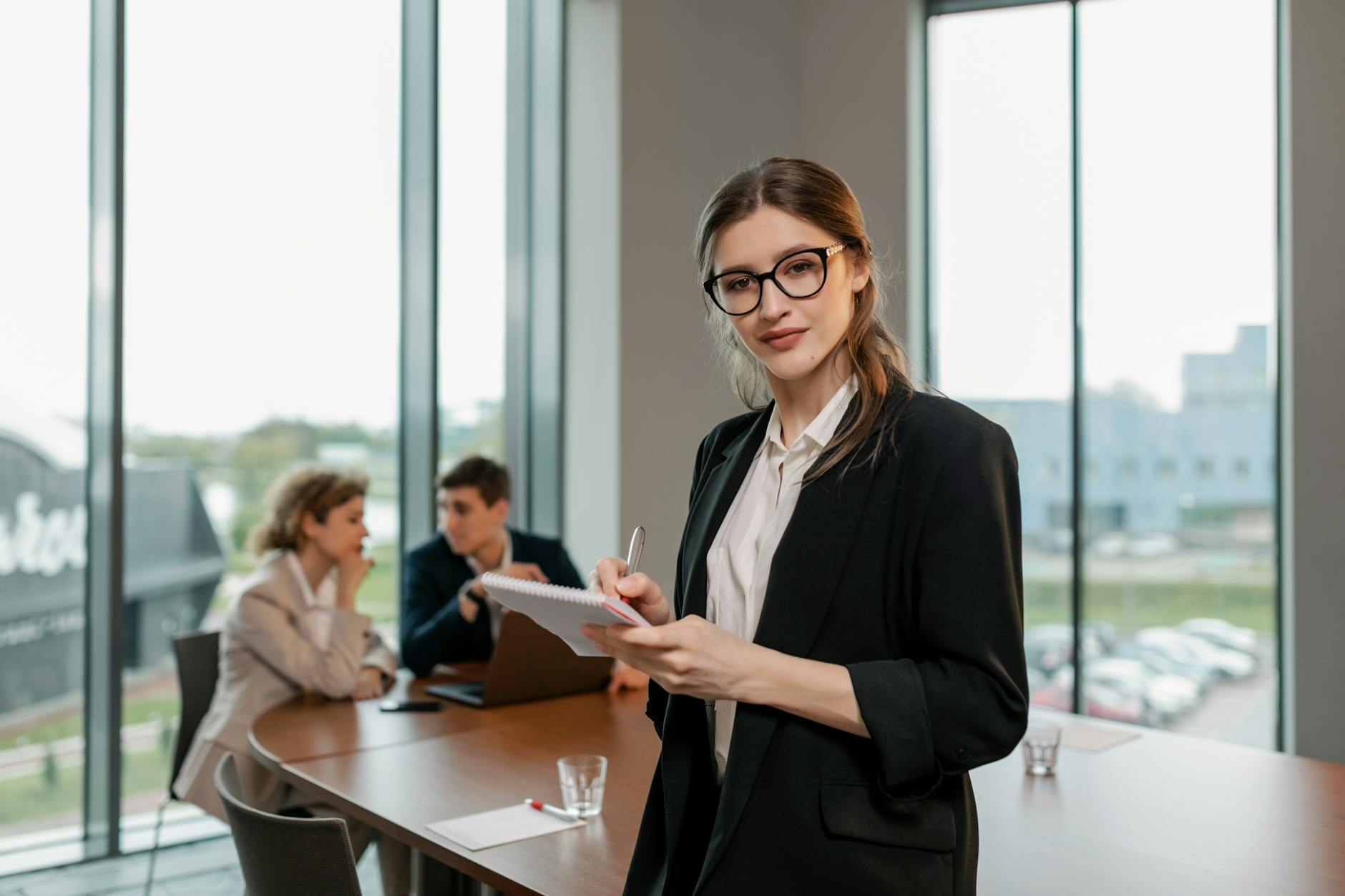 a woman in black blazer holding a notebook