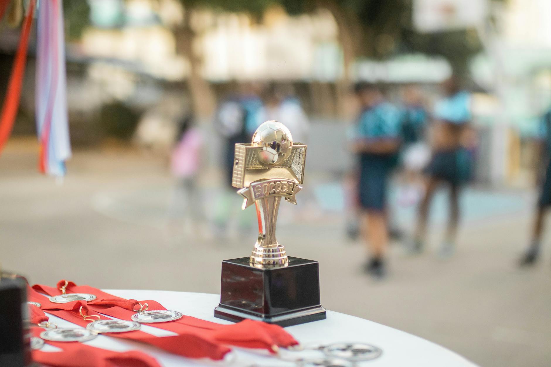 shiny soccer trophy at outdoor award ceremony