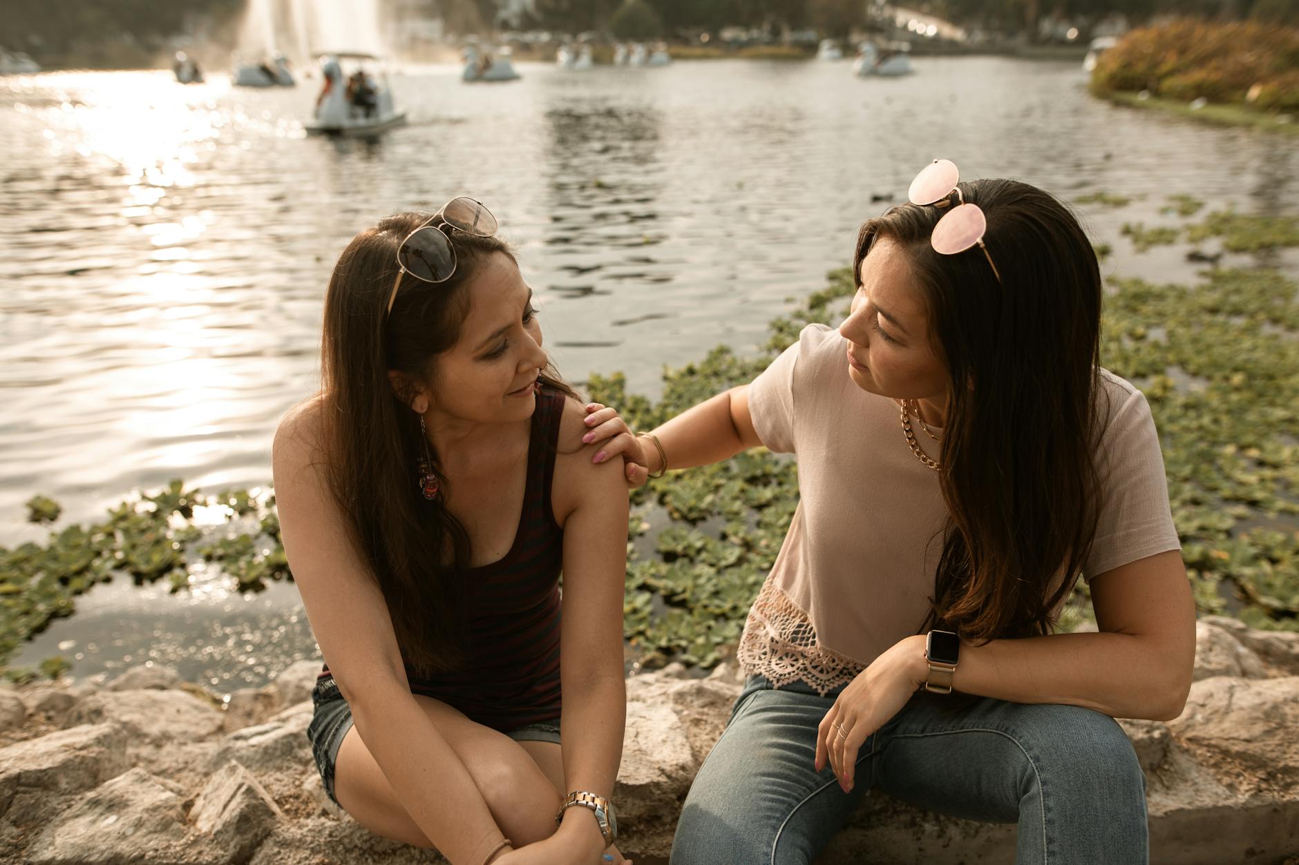 women sitting and talking by a lake