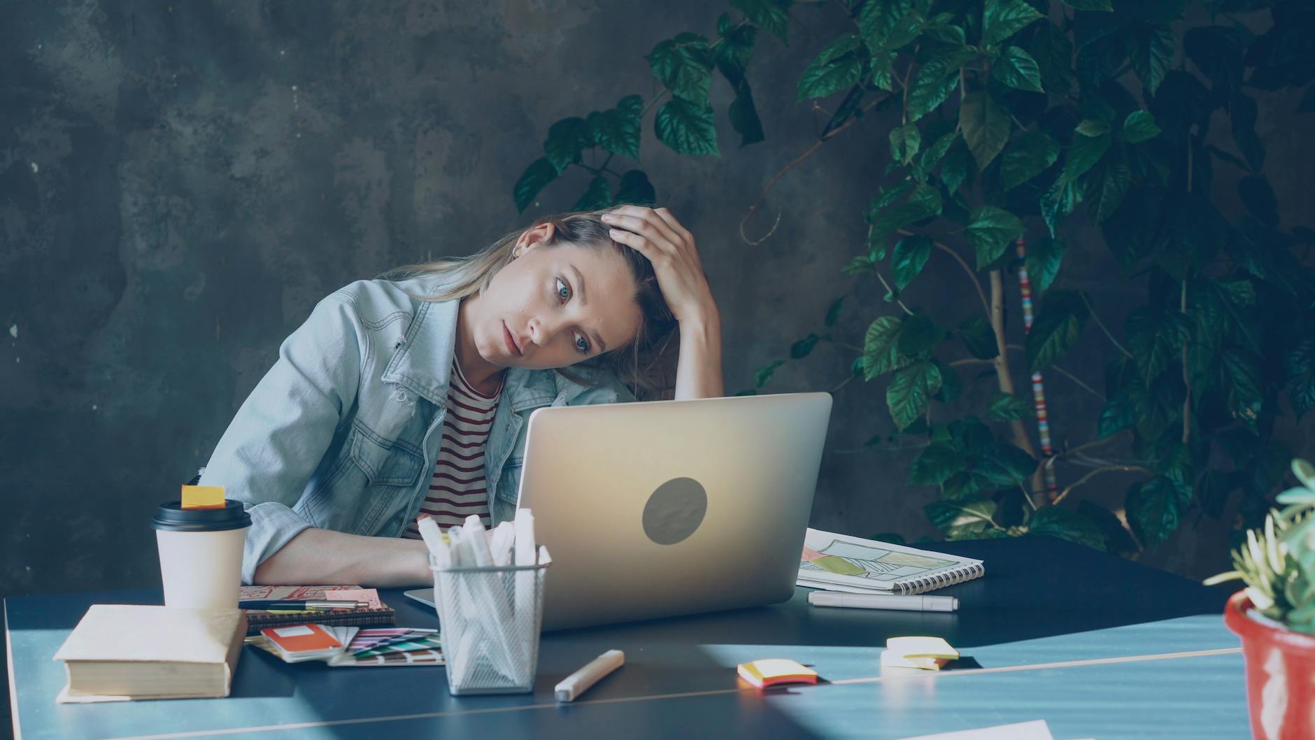 thoughtful woman working at laptop in cozy office
