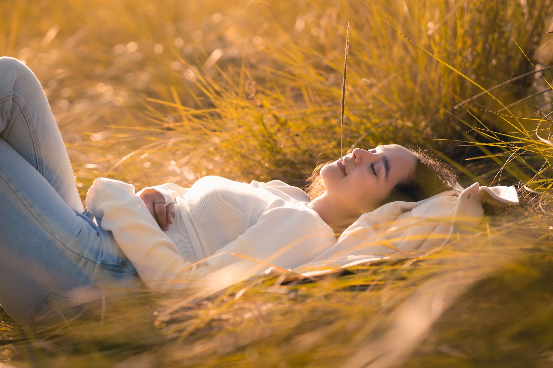young woman relaxing in golden grassy field