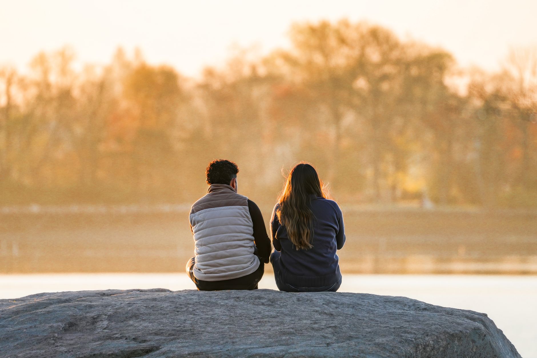couple enjoying an autumn sunset by the lake