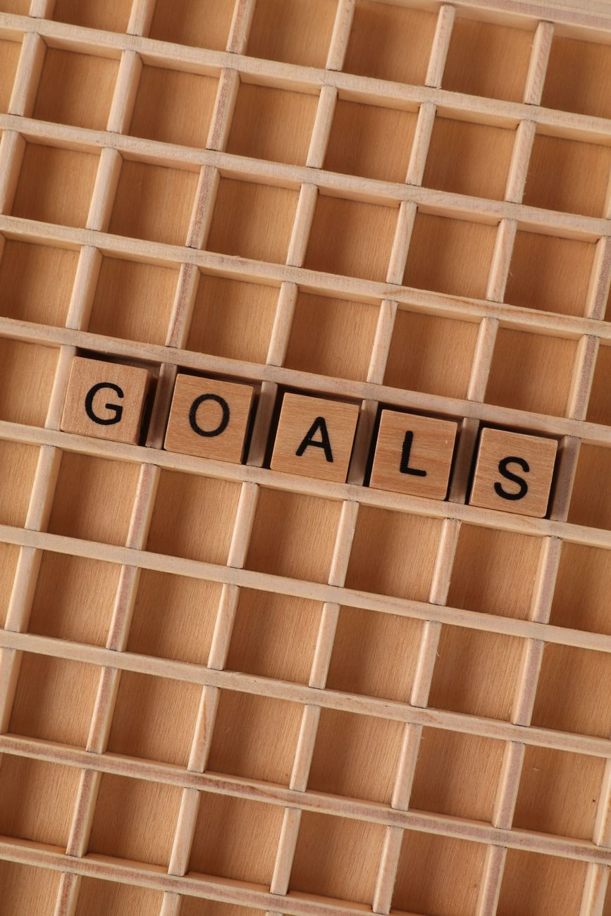 wooden letter blocks spelling goals on grid