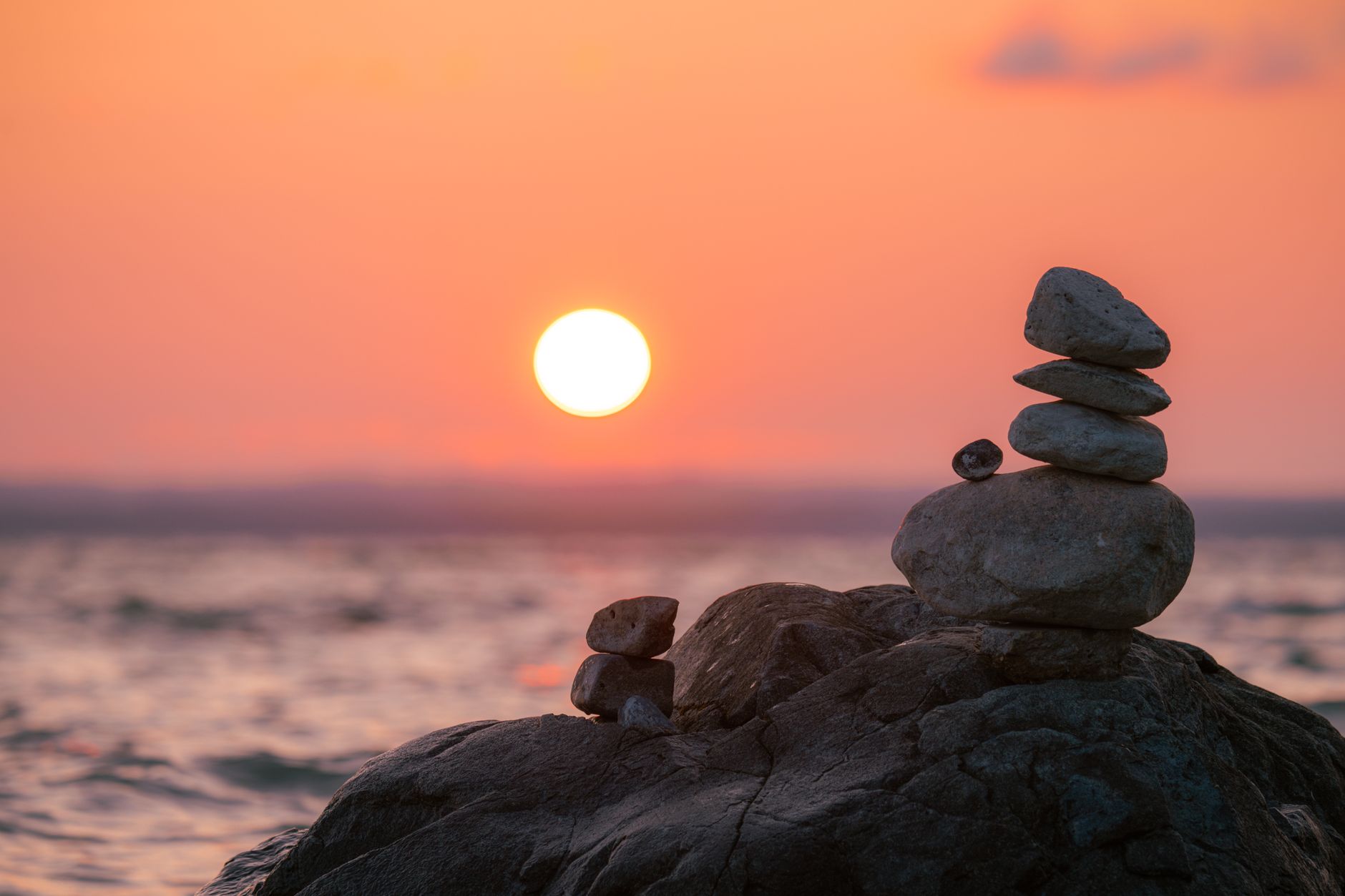 serene sunset over stacked stones by the lake