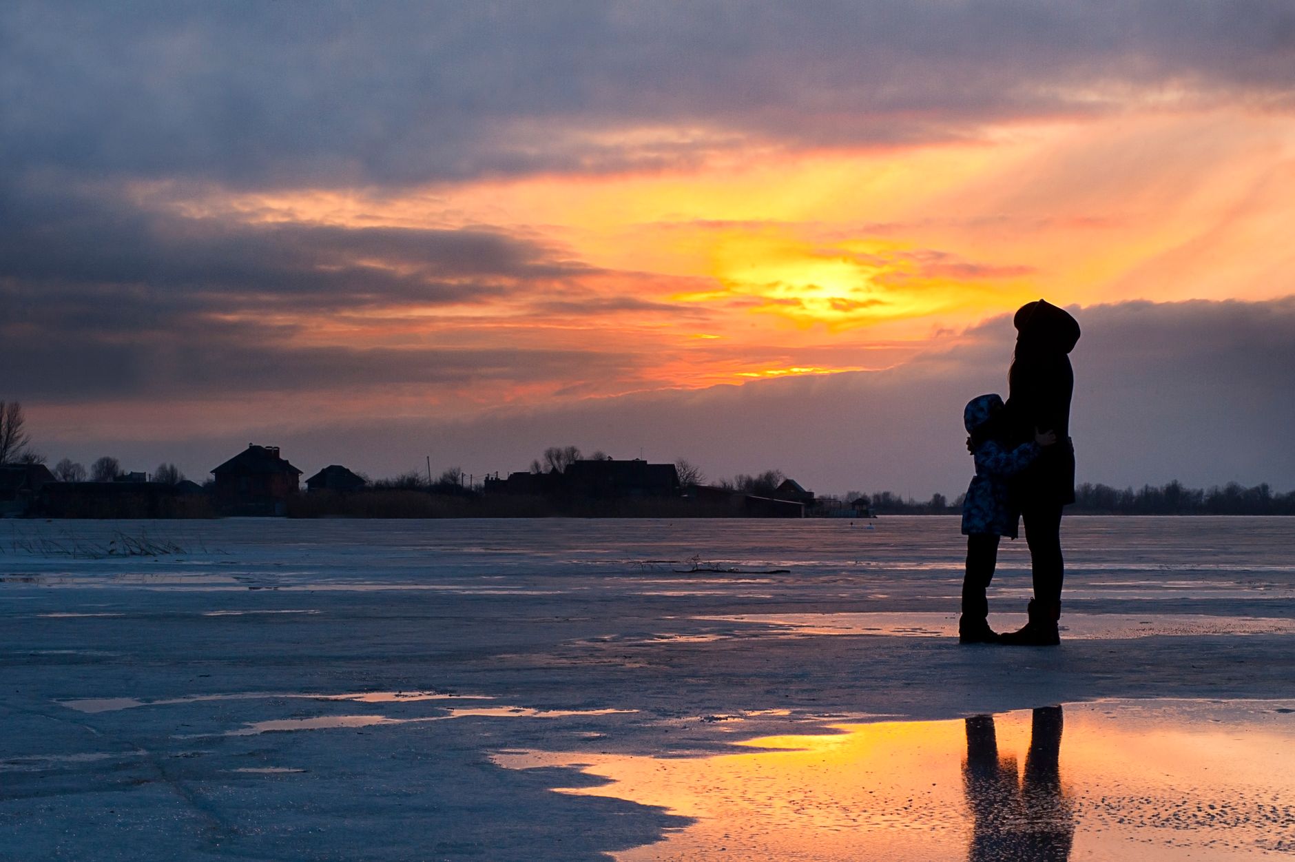 child and woman standing near water