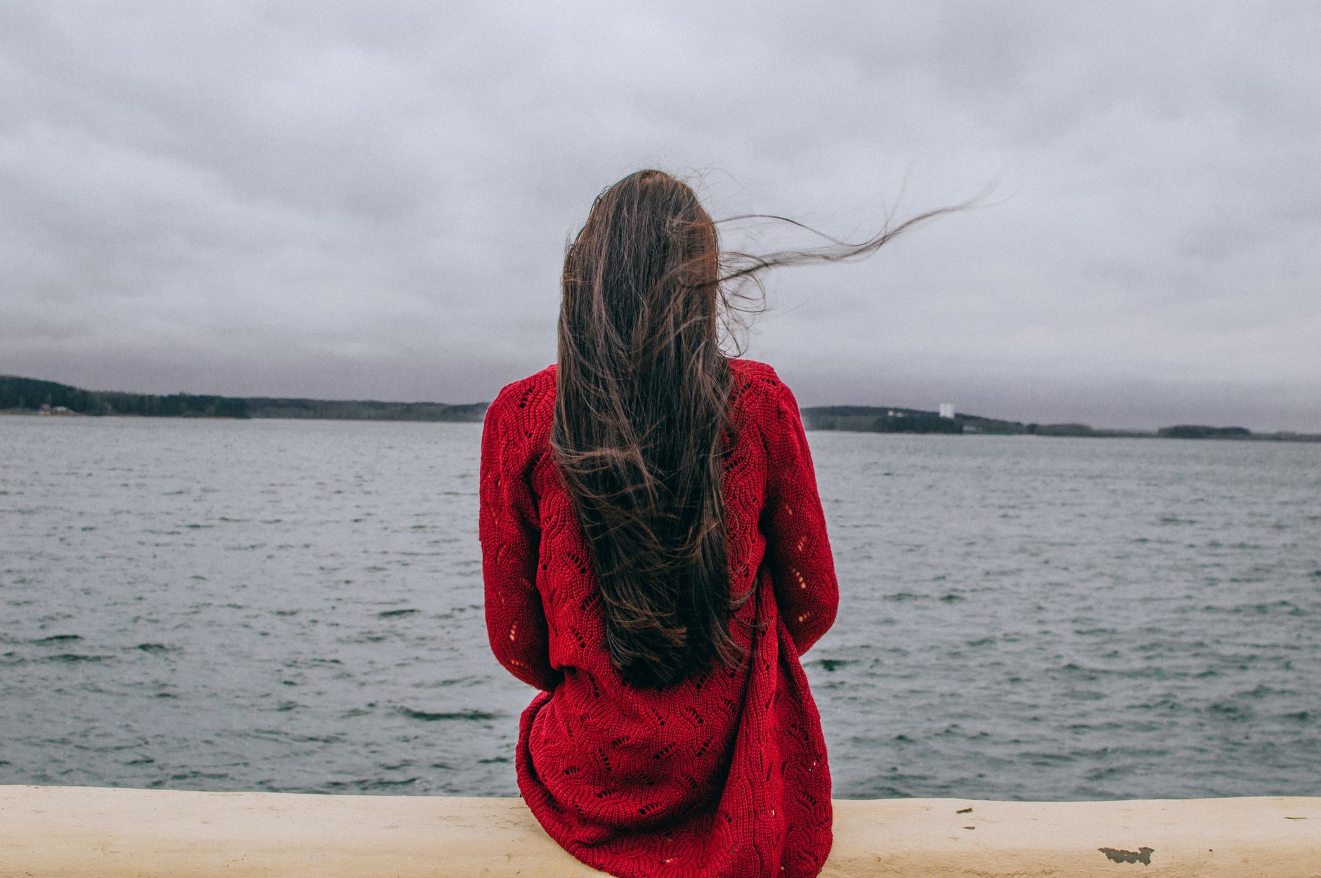 woman sitting and looking at sea