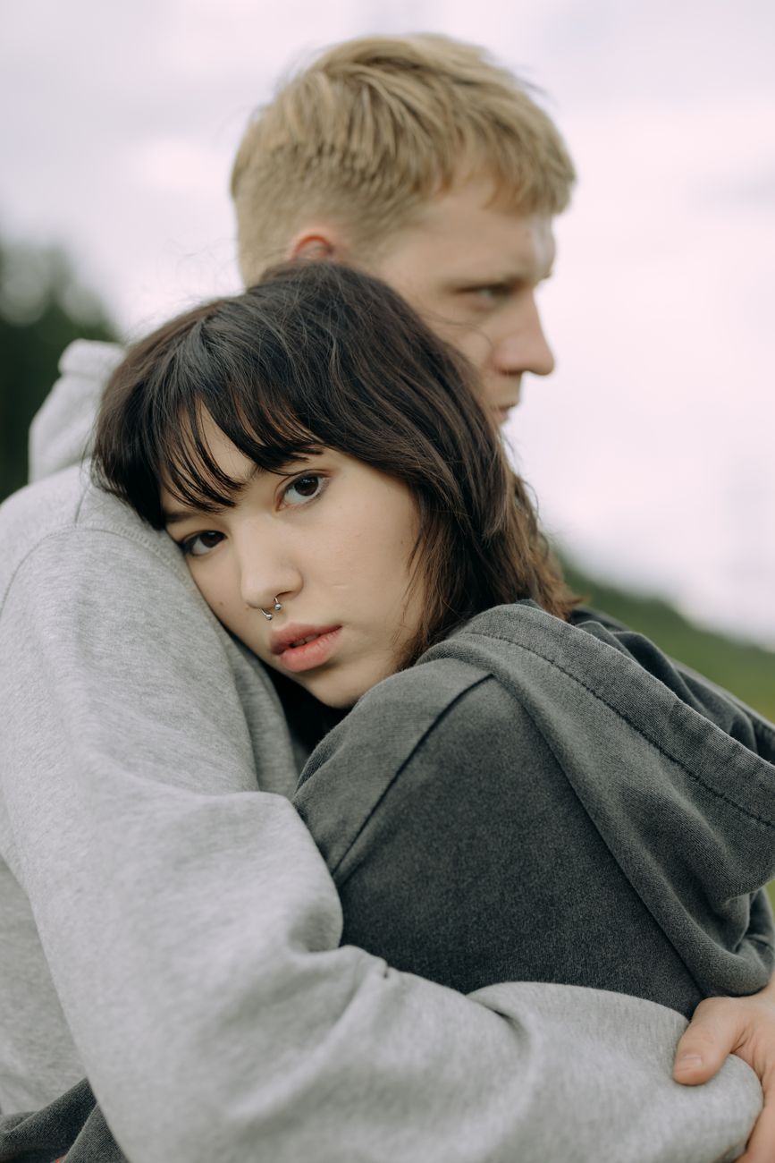 a woman with nose piercing hugging a man